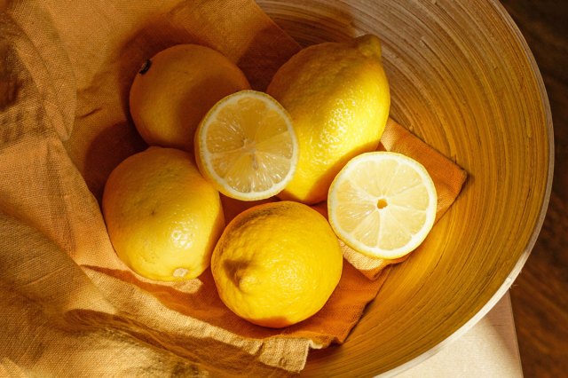 An image of a wooden bowl with lemons