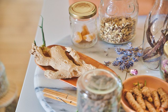 An image of clear glass jars, bowls, and ginger on a countertop