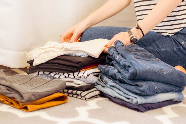 An image of a woman sitting folding laundry