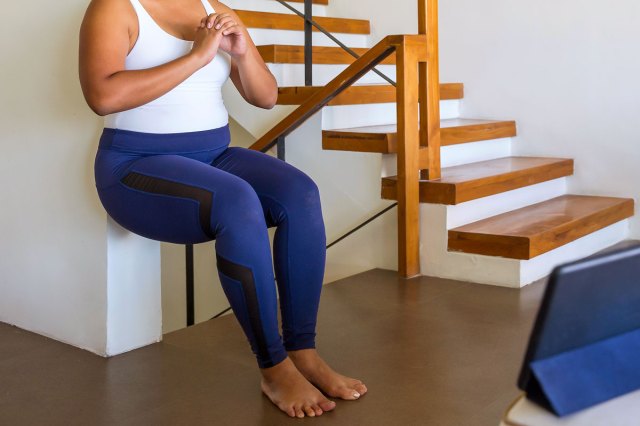 An image of a woman doing a wall sit