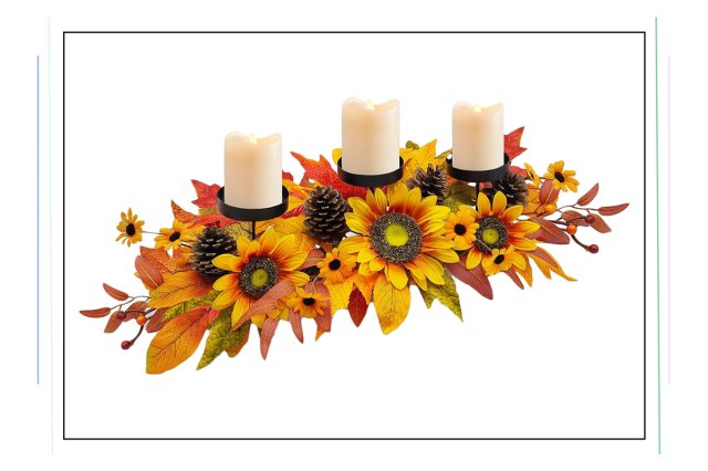 An image of a centerpiece with three candles, sunflowers, and autumn leaves