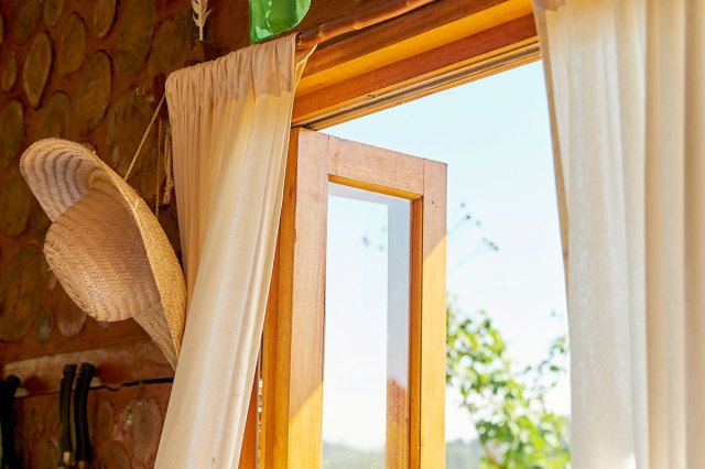 An image of an open door with beige curtains