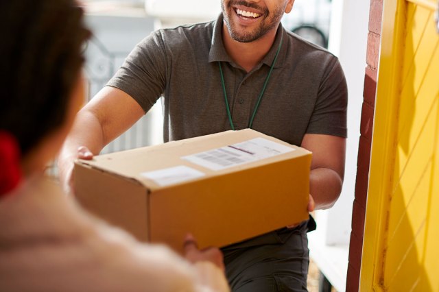 An image of a delivery man handing a box to a person
