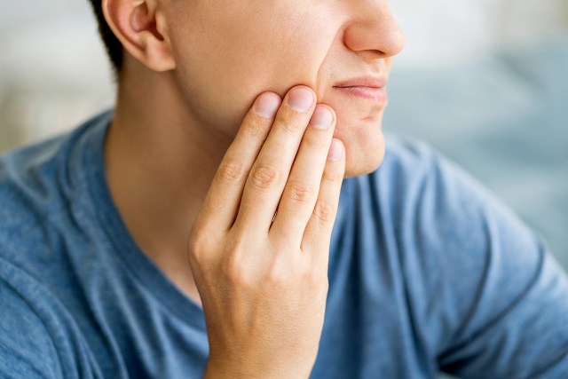 An image of a man holding his jaw