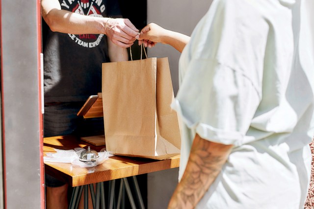 Restaurant worker handing a bag to a customer